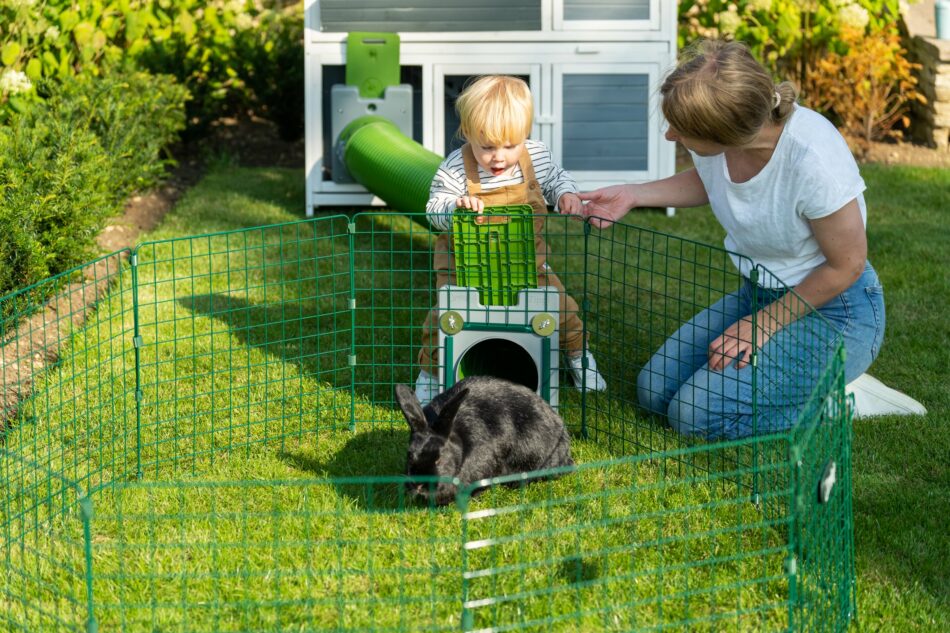 Eine Kaninchenhalterin und ihr Kind mit ihrem Kaninchen und dem Omlet Zippi Tunnelsystem für Kaninchen 