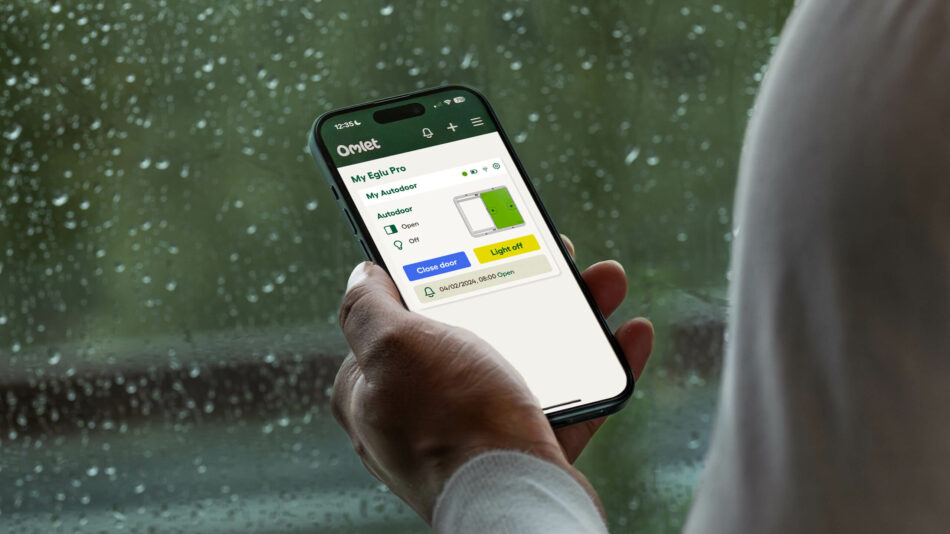 Eine Person benutzt die Omlet-App für die intelligente Autodoor