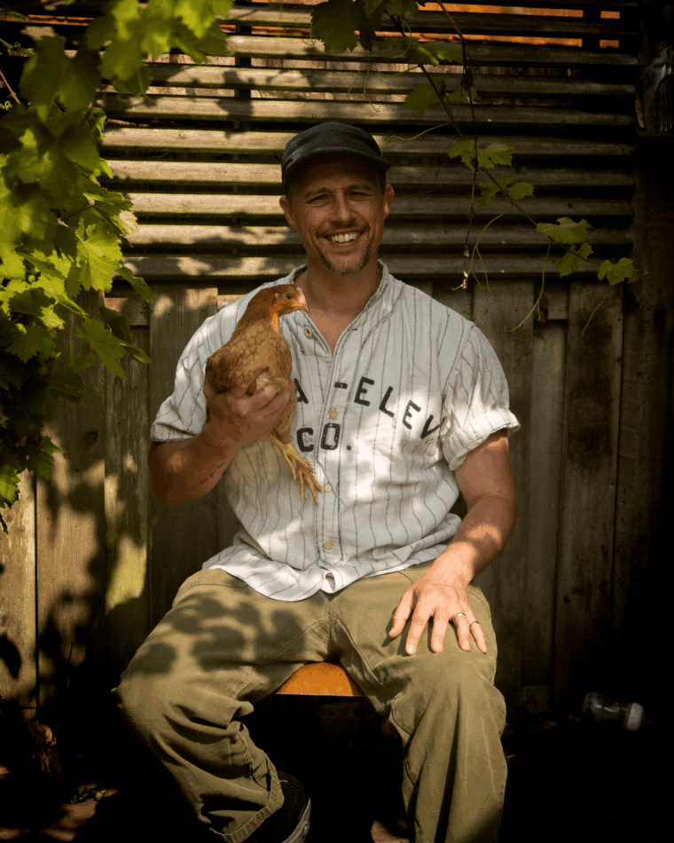 JP Cooper mit einem Huhn auf dem Arm